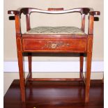 An Edwardian mahogany and painted piano stool with hinged seat, on square tapered stretchered