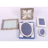 Four silver photograph frames, various, and a silver framed strut clock (damages)