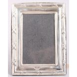 An embossed silver photograph frame, 4 1/2" high