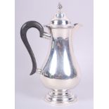 A silver pedestal hot water jug with ebonised handle, 7.8oz troy approx