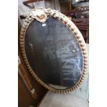 An oval wall mirror with scroll crest and moulded frame, bevelled plate 48" x 33 1/2"