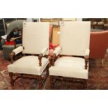 A pair of Restoration design armchairs with carved lion mask arms, upholstered in a cream linen