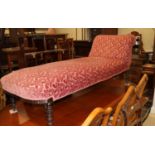 An Edwardian chaise longue, upholstered in a pink brocade, on turned and castored supports