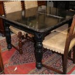 A late Victorian ebonised carved oak extending dining table with one extra leaf, 70" x 40" when