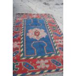 A Turkey carpet with central geometric medallion on a blue ground and hooked guls to the borders,