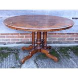 A late 19th century figured walnut loo table, on five turned columns and quadruple splay supports,
