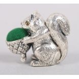 A white metal pin cushion, in the form of a squirrel, stamped sterling, 7" high