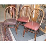 Three oak Windsor wheelback chairs with red leather seats, on turned supports