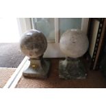 A pair of stone spheres, on stands, 15" high overall