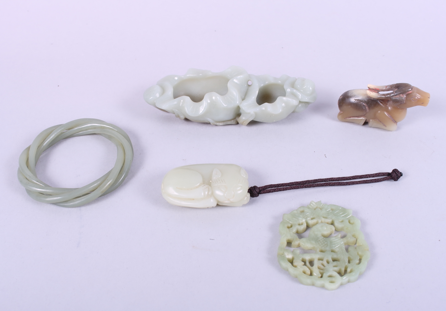 A Jade brush wash, 4 3/4" long, a jade bangle, a model of a cat, a model of a deer and a carved jade