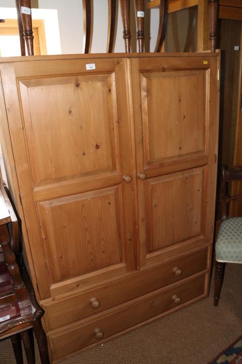 A pine wardrobe enclosed two panelled doors over two long drawers, 42 1/2" wide