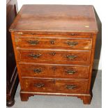 A bachelor's Georgian walnut chest of four graduated drawers with brush slide and string inlay, on