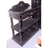 A late Victorian ebonised carved oak three-tier buffet, fitted one drawer, on turned supports, 41"