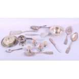 Three white metal serving implements, a number of others, four silver plated bottle stoppers and