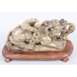 A 19th century Chinese carved soapstone figure of a dragon, 10" long, on hardwood base
