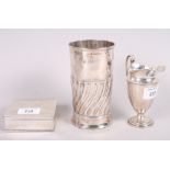 A silver embossed vase, 5 3/4" high, a silver cream jug and a silver cigarette box, 10.2oz troy