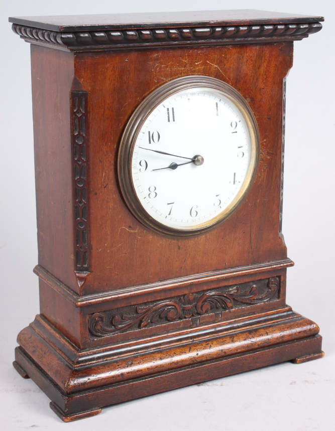 A mahogany cased mantel clock with carved decoration, white enamel dial and Arabic numerals