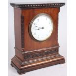 A mahogany cased mantel clock with carved decoration, white enamel dial and Arabic numerals