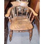 A Windsor tub-shape spindle back elbow chair with panel seat, on turned and stretchered supports