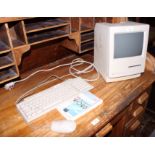 A 1990s Apple Macintosh Classic computer, keyboard and mouse