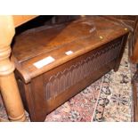 An Ercol design oak coffer with carved front panel, on stile supports, 38 1/2" wide