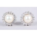 A pair of white metal studded ear clips set diamonds surrounding central pearl, 19.8g gross