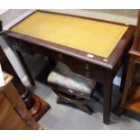 A mahogany writing desk with tooled leather top, fitted one long and four small drawers, on