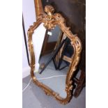 A gilt and ornately carved mirror, 23" wide