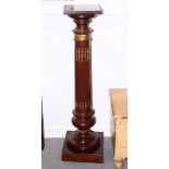 A mahogany torchere, on turned and reeded column with brass mounts and block base, 44" high