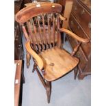 A Windsor spindle back elbow chair with panel seat, on turned and stretchered supports