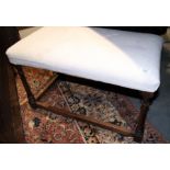 An oak rectangular stool, upholstered in a cream fabric, on turned and stretchered supports, 28"