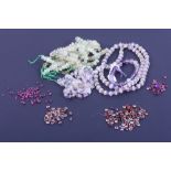 A collection of gemstones, loose and strung, including amethyst, prehnite, garnets, rubies, etc,