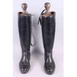 A pair of leather riding boots and trees with pulls