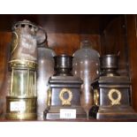 An Ackroyd & Best brass and metal miner's lamp and two storm lamps with cold cast bases