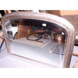 A carved silvered frame overmantel mirror with bevelled glass, 42 1/2" wide