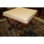 A 19th century carved rosewood "X" framed dressing stool, upholstered in a floral fabric, 23" wide