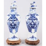 A pair of 19th century Chinese oviform blue and white vases with covers, decorated figures in a