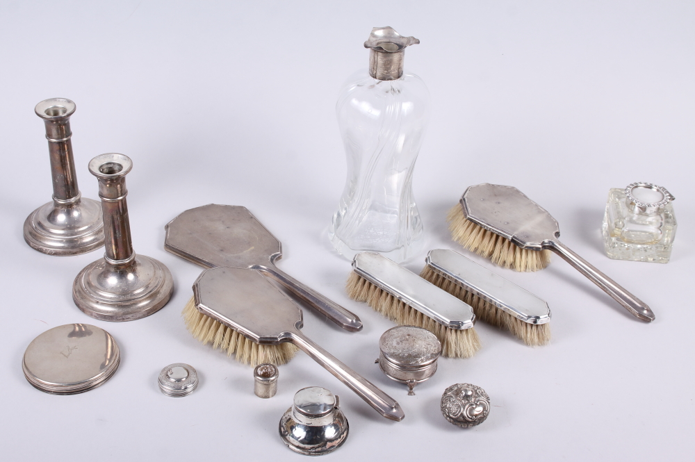 A pair of cylindrical silver candlesticks, two silver inkwells, a silver backed dressing table set