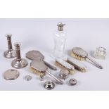 A pair of cylindrical silver candlesticks, two silver inkwells, a silver backed dressing table set