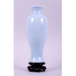 A Chinese porcelain monochrome pale blue oviform vase, on hardstone stand, 10" high