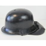 A WWII German fire fighters helmet with liner and chinstrap, having makers marks upon,