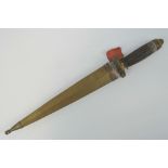 An Arabic/Ottoman dagger having ornate carved horn 'Roman style' grip and a brass sheath.