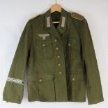 A WWII German Afrika Korps tunic complete with cuff title and cloth badges.