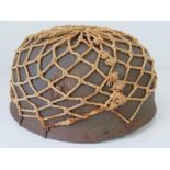 A fine replica WWII German Luftwaffe Paratroopers helmet having single decal, camouflage netting,