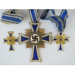 A WWII German Mothers Cross medal with two miniatures and original ribbons.