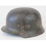 A fine replica WWII German helmet with Wehrmacht decal and painted in woodland style camo.