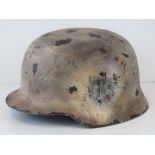 A fine replica WWII German helmet with Wehrmacht decal and painted in eastern front Winter style