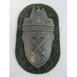 A WWII German Demjansk Shield badge on Wehrmacht cloth backing, dated 1942.