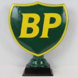 A large contemporary free standing BP petroleum shield in case metal raises on a square shaped base.