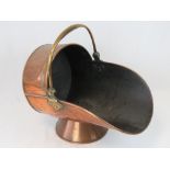 A Victorian copper coal scuttle with swing handle.